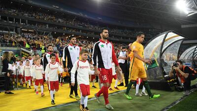 Syria and Australia walk out onto the pitch prior to kick off. David Moir / EPA