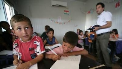 Children attend a class at the Domiz refugee camp, 20km southeast of the northern Iraqi city of Dohuk, which houses Syrian-Kurd refugees.