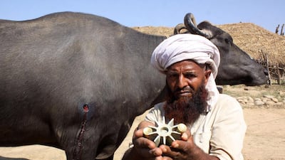 A villager displays parts of a mortar shell casing which he says hit his home and his livestock at the village in Jodafarm, in Kashmir. AFP