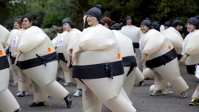 Participants warm up before The Sumo Run in Battersea Park, London July 27, 2014. The runners, wearing inflatable costumes, take part in the 5km run with the aim of raising money for a charity to help educate children in Africa. Reuters