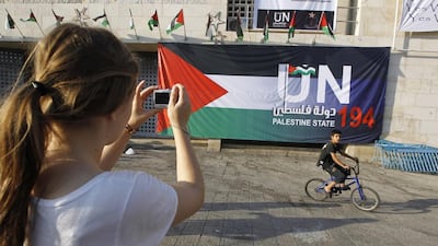 A tourist takes a picture of a Palestinian flag at Manger Square in the West Bank town of Bethlehem. Ammar Awad / Retuers
