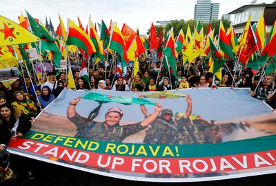 Kurdish protesters hold banner and flags at a demonstration against Turkey's military action in northeastern Syria, in Cologne, Germany. Thilo Schmuelgen / Reuters