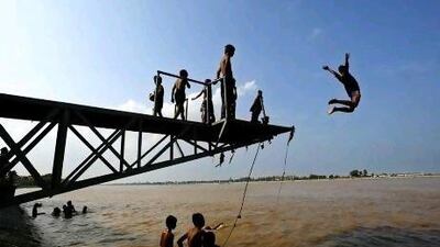 Cambodian children jump off a platform into the Tonle Sap river where it meets the Mekong River in Phnom Penh, Cambodia. AP Photo/Andy Eames