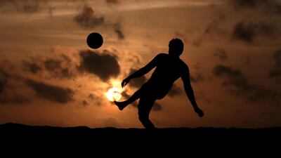 A boy is silhouetted against the sunset as he plays with a soccer ball in Colombo, Sri Lanka. Reuters