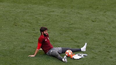 Liverpool goalkeeper Alisson sits on the pitch during training. AP Photo