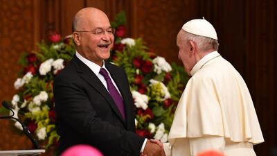 Pope Francis shakes hands with Iraqi President Barham Salih at the Presidential Palace. AFP