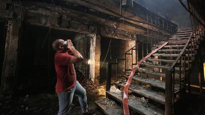 A Iraqi rescue worker looks for victims at the site of a car bomb attack on a commercial area in Karada, Baghdad (AP Photo/Hadi Mizban)