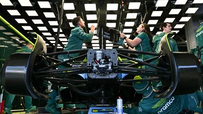 Pit crew work on the car of Aston Martin's Canadian driver Lance Stroll before the start of the second practice session of the Formula One Japanese Grand Prix in Suzuka. AFP