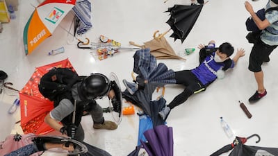 Police officers scuffle with protesters inside a shopping mall in the Sha Tin District of Hong Kong. Police in the territory fought protesters as they broke up a demonstration by thousands of people demanding the resignation of chief executive Carrie Lam and an investigation into complaints of police violence. AP