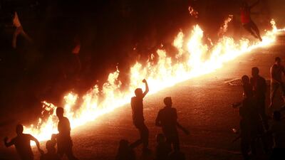 Protesters jump and run near a line of fire during a demonstration in Cairo October 9, 2011. Nineteen people were killed in Cairo on Sunday when Christians, some carrying crosses and pictures of Jesus, clashed with military police, medical and security so???