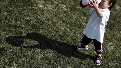 Two-year old Miyabi Goto plays with a rugby ball during a skills camp in Tokyo this month. Yuya Shino / Reuters
