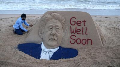 Indian sand artist Sudarsan Pattnaik touches up a sculpture for Mr Abe at the Puri Beach, near Bhubaneswar, India, August 29. EPA