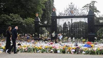 The Prince and Princess of Wales walk near the floral tributes at the gates of Sandringham House. PA