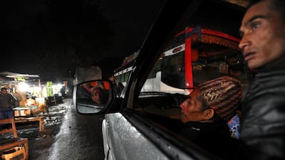 Chandra Bahadur Dangi (C), a 72-year-old Nepali who claims to be the world's shortest man at 56 centimetres (22 inches) in height, sits with his nephew in a jeep on their way home in Hetauda, Makawanpur district, southern Nepal. AFP PHOTO/Prakash MATHEM??