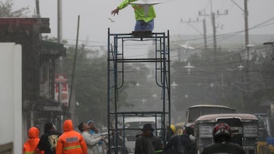 A man prepares to take down Christmas lanterns ahead of approaching Typhoon Kammuri. AP Photo
