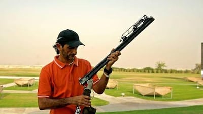 Emirati Olympic shooting gold medalist Sheikh Ahmed bin Hasher Al Maktoum, a member of Dubai's ruling family, fixes his Beretta competition shotgun during a training session.