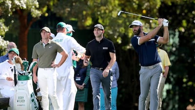 Dustin Johnson tees off of the 16th hole as Rory McIlroy, left, and Patrick Cantlay, second from left, watch. PA