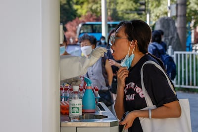 A woman undergoes a Covid-19 test in Beijing. China's infection numbers are on the rise again. EPA