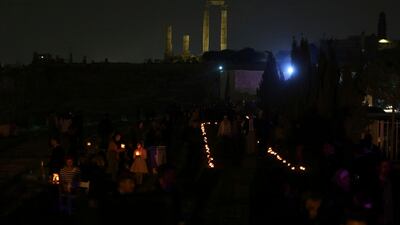People hold candles as they gather at Amman Citadel to light candles that form the Earth Hour logo, in an official attempt to be registered in the Guinness Book of Records for the largest candle-shaped World Hour logo, in Amman, Jordan. Raad Adayleh / AP Photo