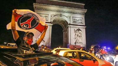 A supporter of the Paris Saint Germain soccer team celebrates on the Champs Elysee in Paris, AP