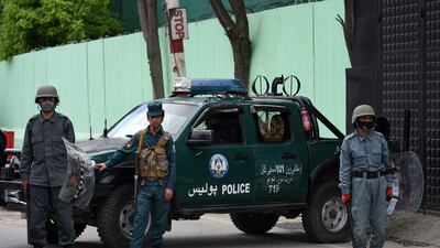 Afghan security personnel stand guard as civil society activists (not pictured) hold banners and shout slogans against the Iranian government during a protest in front of the Iranian embassy in Kabul on May 11, 2020. AFP