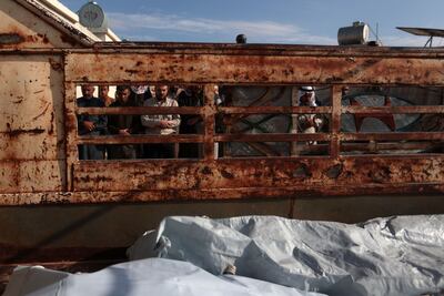 People pray over the bodies of an elderly woman and four of her children killed during an overnight bombardment by Syrian regime forces on the outskirts of Kfar Nuran, in the rebel-held part of the western province of Aleppo. AFP