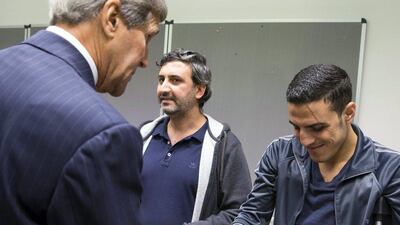 US Secretary of State John Kerry talks with a man injured in a bomb attack in Syria during a meeting with a group of refugees fleeing Syria at Villa Borsig in Berlin, Germany on September 20. Evan Vucco / AFP