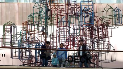 Residents past by a wire frame sculpture resembling houses in Beijing. The ongoing trade war and slowing economic growth have raised hopes of a revival in buying. AP Photo