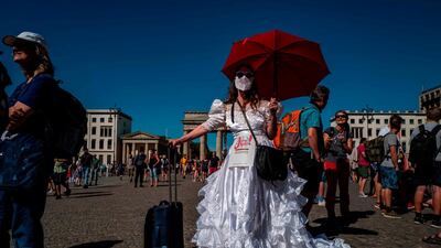 A demonstrator in a wedding gown poses in front of the Brandenburg Gate with a sign reading: Yes to the (Germany's) basic law as she takes part in a demonstration by the initiative Querdenken-711 with the slogan 'The end of the pandemic - the day of freedom' to protest against the current measures to curb the spread of the Coronavirus in Berlin. AFP