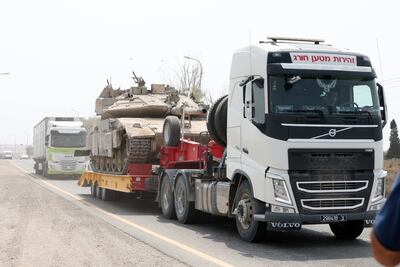 A lorry carries an Israeli tank near the border with Gaza, as Israel prepares to expand its offensive. EPA