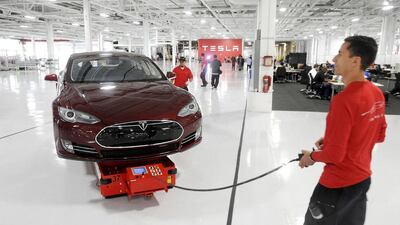 Mark Cuyler, an operations manager at Tesla, walks a Model S through the company’s factory in California. Tesla began delivering the electric sedan to customers on June 22, 2012. Noah Berger / Reuters