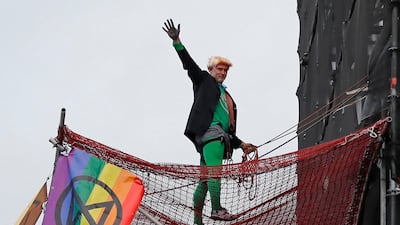 A climate activist dressed as Britain's Prime Minister Boris Johnson gestures after climbing scaffolding and unfurling banners on the Elizabeth Tower, commonly known by the name of the bell, Big Ben on the twelfth day of demonstrations by the climate change action group Extinction Rebellion, in London, on October 18, 2019. AFP / Tolga AKMEN