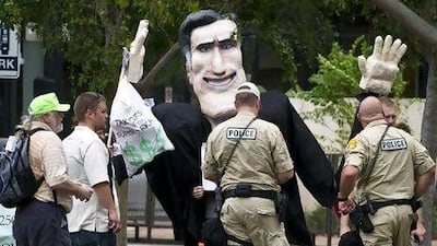 Police officers check the documents of protesters carrying an effigy of US Republican Party presidential candidate Mitt Romney during a demonstration outside a Republican national convention in Tampa, Florida.
