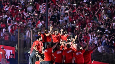 Egypt's returning World Cup players wave from an open-top bus to cheering fans as they enter Cairo International Stadium. AFP