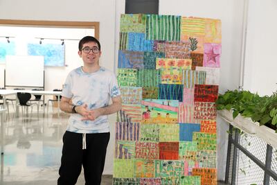 Sean McLennan, an artist with special needs, with his collage at the Mawaheb studio in Al Quoz in Dubai. Pawan Singh / The National