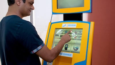 Employees at the FMW/ManGo offices in Dubai Media City demonstrate the new payment kiosk machine which also accepts Bitcoin. This is the first Bitcoin enabled machine in the UAE. Photo by Clint McLean for The National