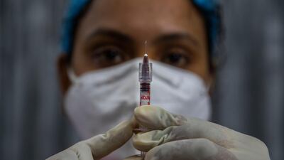 A health worker checks a syringe before performing a trial run of Covid-19 vaccine delivery system in Gawahati, India. AP Photo