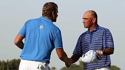 Robert Karlsson, left, shakes hands with Thomas Bjorn at the end of the third round's play.