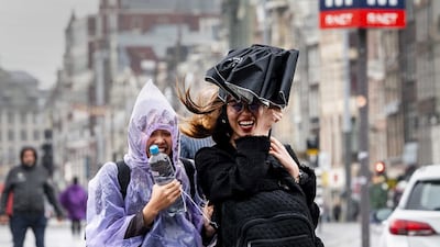 People brave the rough weather in Amsterdam. EPA