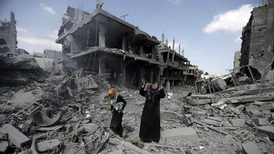 A woman pauses amid destroyed buildings in the northern district of Beit Hanun in the Gaza Strip during a truce on July 26. Mohammed Abed / AFP