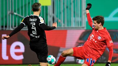 Bayern Munich's Thomas Mueller and Stefan Thesker of Holstein Kiel challenge for the ball. AFP