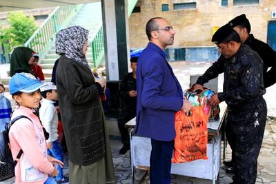 Policemen inspect passengers' bags before they board the train from Baghdad to Fallujah. Reuters
