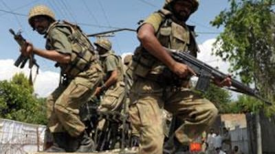 Pakistani army soldiers jump from a vehicle as they patrol Mingora, the capital of the troubled Swat valley