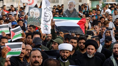 People hold Palestinian flags as supporters of Iraqi Shiite armed groups gather during a protest against the US for supporting Israel, in Najaf, Iraq. Reuters