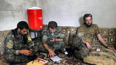 British citizen Jac Holmes, right, with Kurdish commanders at a front-line base in the northern Syrian city of Raqqa on July 18, 2017. The Syrian-Kurd YPG militia reported on October 25 last year that Holmes, a 24-year-old from Bournemouth, had died while clearing mines following the liberation of the city from ISIL. Hussein Malla / AP Photo