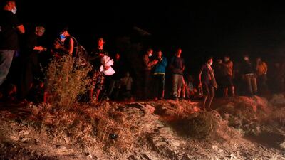 Refugees wearing facemasks gather outside the Moria camp on the island of Lesbos during a major fire there. AFP