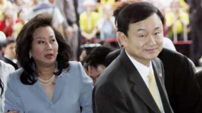 In this July 31, 2008 file photo, deposed Thai Prime Minister Thaksin Shinawatra and his wife Pojaman Shinawatra arrive at criminal court in Bangkok.