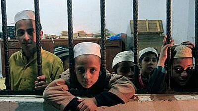 Children look through window of a room after being rescued by police during a raid at a self-styled Islamic seminary on the outskirts of Karachi yesterday.