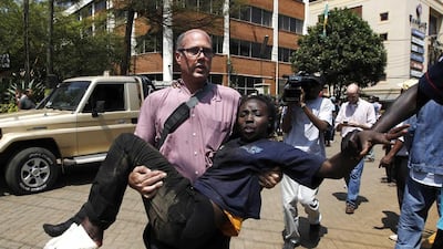 A journalist carries a woman injured during an attack at the upscale Westgate shopping mall in Nairobi on Saturday. Thomas Mukoya / Reuters