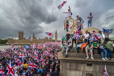 Protesters wave Union Jack and St George's flags during the 'Unite The Kingdom' rally in London. Getty